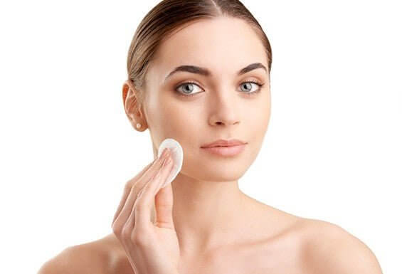 Model applying MD Skin Balancing Solution with cotton pad – gentle toner for oily, sensitive skin to reduce shine and rebalance pH